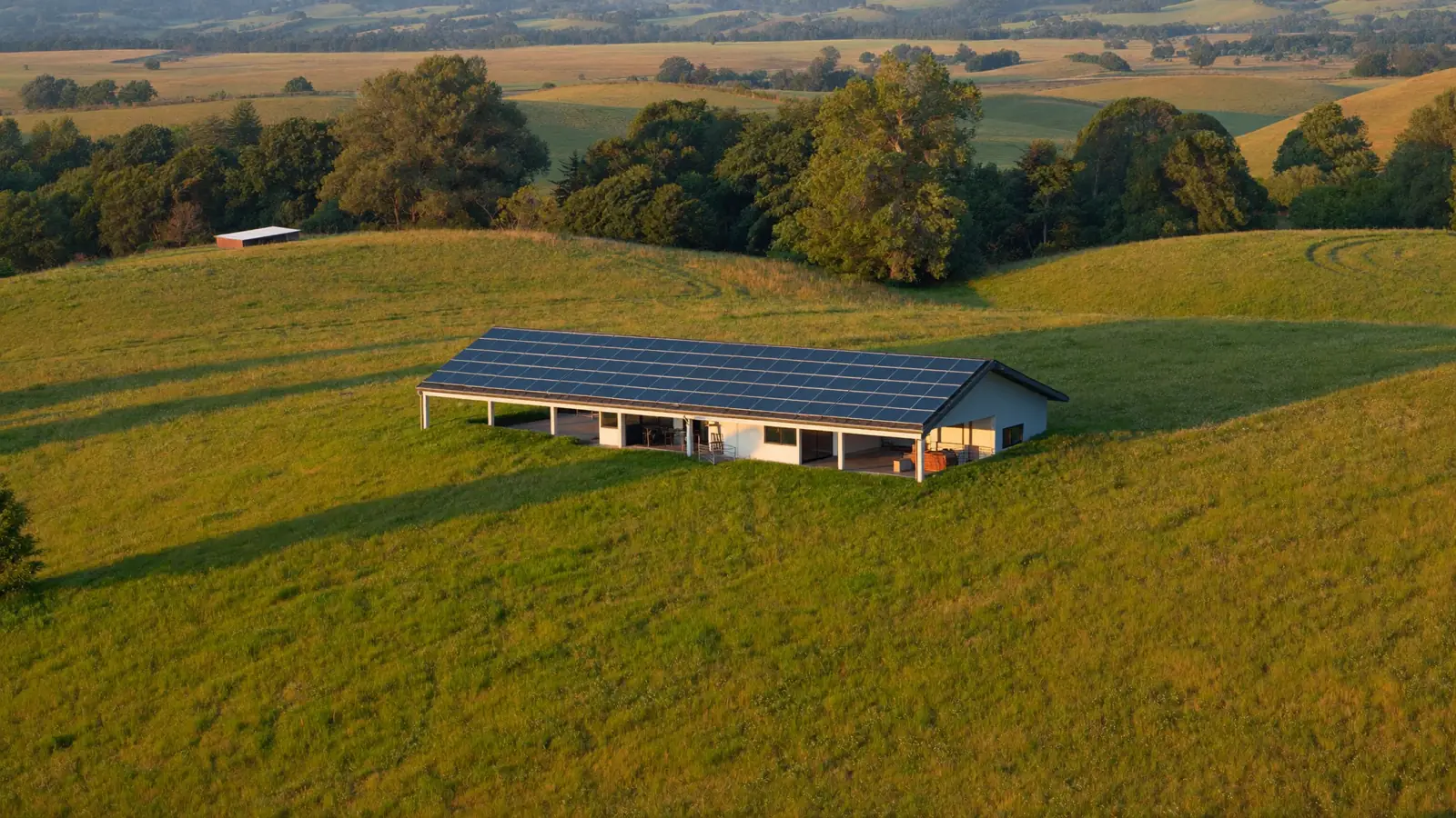 A house with a full roof array set in open meadow