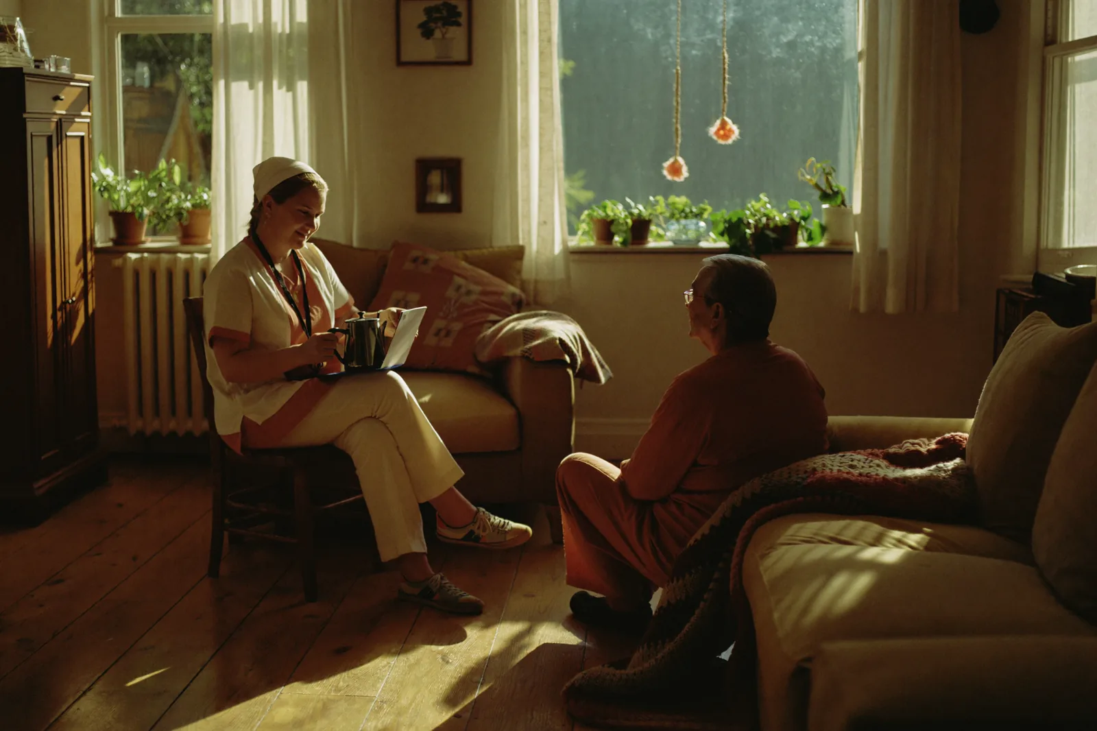 A caregiver walking slowly beside an older person in the garden