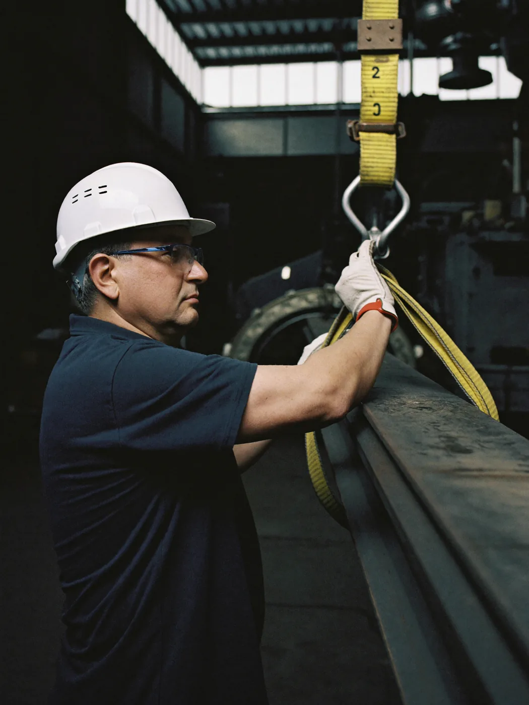 A fabricator checking the finish along a steel beam