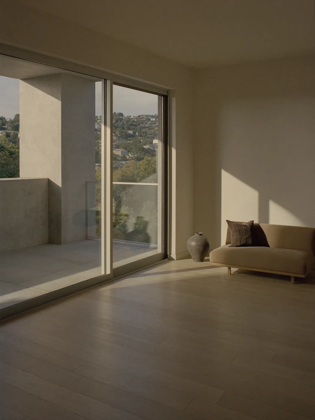 A living room opening to a balcony in late afternoon light