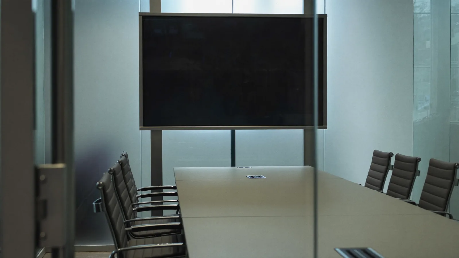 An empty glass-walled meeting room ready for a session