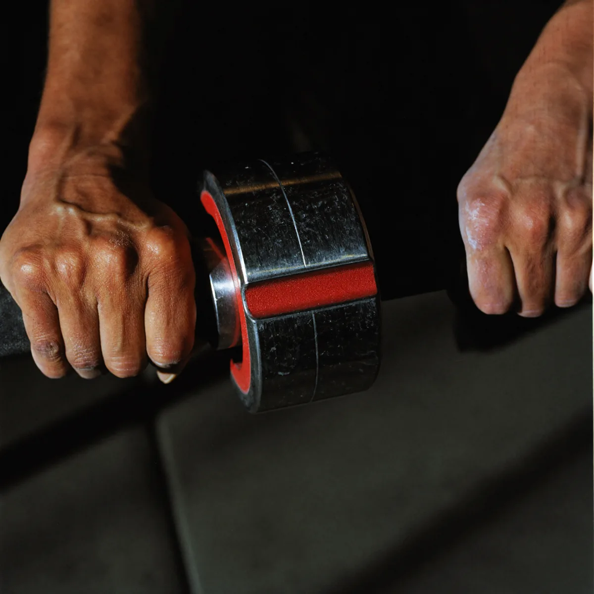 Chalked hands gripping a loaded barbell